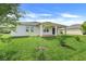 Backyard featuring a covered patio, lush green grass, and young trees at 1706 Lake Sims Pkwy, Ocoee, FL 34761