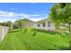 Spacious backyard featuring green lawn, white fence, and covered patio at 1706 Lake Sims Pkwy, Ocoee, FL 34761