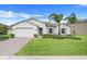 Charming home with a green lawn, complemented by tasteful landscaping and a brick driveway at 1706 Lake Sims Pkwy, Ocoee, FL 34761