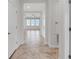 Bright hallway with neutral tile flooring, leading to a naturally-lit living area through white doors at 1706 Lake Sims Pkwy, Ocoee, FL 34761