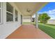 Covered patio with ceiling fan offers a relaxing outdoor space with view of manicured lawn at 1706 Lake Sims Pkwy, Ocoee, FL 34761