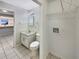 Bright bathroom with a vanity, toilet, laundry hookups and a glimpse into the adjacent kitchen at 1912 Cattleya Dr, Kissimmee, FL 34741