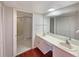 Bright bathroom featuring double sinks, white cabinets, and a large mirror at 1912 Cattleya Dr, Kissimmee, FL 34741