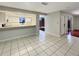 Open living space with tiled flooring and a view to the kitchen and outdoor patio through sliding glass doors at 1912 Cattleya Dr, Kissimmee, FL 34741