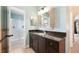 Bathroom vanity featuring dark wood cabinets, a granite countertop, and shuttered mirror at 2020 Corner Glen Dr, Orlando, FL 32820