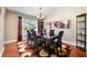 Dining room with dark wood table set for six and a patterned rug underneath a window at 2020 Corner Glen Dr, Orlando, FL 32820