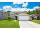 Charming two-story home with a well-manicured lawn and attached two car garage on a sunny day with blue sky at 2020 Corner Glen Dr, Orlando, FL 32820