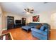 Comfortable living room with hardwood floors, a blue sectional sofa, a ceiling fan and built-in shelving at 2020 Corner Glen Dr, Orlando, FL 32820