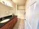 Well-lit bathroom with granite countertop, wooden cabinets, and shower with curtain at 2528 Robert Trent Jones Dr # 1617, Orlando, FL 32835