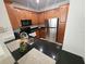 Modern kitchen featuring black countertops, wood cabinets, and stainless steel refrigerator at 2528 Robert Trent Jones Dr # 1617, Orlando, FL 32835