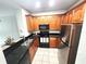 Bright kitchen with stainless steel appliances, black counters, tile flooring and wood cabinets at 2528 Robert Trent Jones Dr # 1617, Orlando, FL 32835