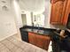 Cozy kitchen features black appliances, black countertops and tile flooring at 2528 Robert Trent Jones Dr # 1617, Orlando, FL 32835