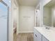 Bright bathroom with white vanity, framed mirror, and tiled floor, plus a partially visible glass-enclosed shower at 2731 Forestdale St, St Cloud, FL 34771