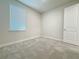 Bedroom with neutral carpet, bright window, and white door at 2731 Forestdale St, St Cloud, FL 34771
