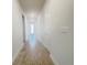 Hallway with wood-look tile flooring leads to rooms with white walls and doors, creating a bright and inviting atmosphere at 2731 Forestdale St, St Cloud, FL 34771