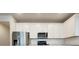 Close-up of kitchen, showing stainless steel appliances, white cabinets, and quartz countertops at 2731 Forestdale St, St Cloud, FL 34771