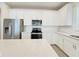 Bright kitchen features stainless steel appliances, white cabinets, and a large island with quartz countertops at 2731 Forestdale St, St Cloud, FL 34771