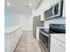 Modern kitchen boasts stainless steel appliances, white cabinets, and quartz countertops at 2731 Forestdale St, St Cloud, FL 34771