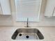 Close-up of a stainless steel kitchen sink and quartz countertops at 2731 Forestdale St, St Cloud, FL 34771