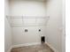 Bright laundry room with overhead shelving, tile floors, and convenient hookups at 2731 Forestdale St, St Cloud, FL 34771