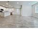 Bright living room featuring wood-look flooring that opens to a modern kitchen with white cabinets and stainless steel appliances at 2731 Forestdale St, St Cloud, FL 34771