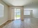 Open living area showcasing wood-look tile flooring, a sliding glass door, and large windows for ample natural light at 2731 Forestdale St, St Cloud, FL 34771
