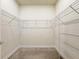 Spacious walk-in closet features carpeted floors, white walls, and wire shelving for optimal storage solutions at 2731 Forestdale St, St Cloud, FL 34771