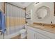 Cozy bathroom with a vanity sink, a shower with a patterned curtain, and decorative wall shelving at 303 W Par St, Orlando, FL 32804