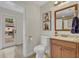 Bathroom with wood vanity, tile floor, toilet, and patio view through the glass door at 303 W Par St, Orlando, FL 32804