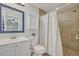 Clean bathroom featuring a shower with tile surround, a white vanity, and a framed mirror at 303 W Par St, Orlando, FL 32804