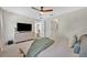 Relaxing bedroom with a ceiling fan, TV, and a comfortable bed with a soft blanket draped across it at 303 W Par St, Orlando, FL 32804