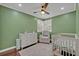 Charming Bedroom with soft green walls, a white crib, a dresser, and a comfortable rocking chair at 303 W Par St, Orlando, FL 32804