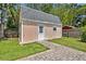 View of the shed with a gray roof and pink wood plank walls and a cobblestone path at 303 W Par St, Orlando, FL 32804