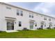 New townhome exterior with a white back side featuring a sliding glass door, green lawn, and air conditioner at 3239 Laurent Loop, Davenport, FL 33837
