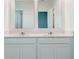 Bathroom featuring a double vanity with quartz countertops and a neutral color palette, offering a clean and modern design at 3239 Laurent Loop, Davenport, FL 33837