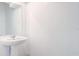 Bright white bathroom features a pedestal sink with a large mirror and clean white walls at 3239 Laurent Loop, Davenport, FL 33837