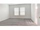 Well-lit bedroom featuring neutral carpet, large windows, and an attached bathroom with a glass-enclosed shower at 3239 Laurent Loop, Davenport, FL 33837