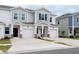 Townhome exterior with a 2-car garage, stone accents, and light gray siding at 3239 Laurent Loop, Davenport, FL 33837