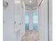 Hallway with neutral carpet, leading to rooms with louvered air vents and doors with chrome hardware at 3239 Laurent Loop, Davenport, FL 33837