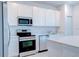Modern kitchen featuring stainless steel appliances and white cabinets for a sleek, contemporary cooking space at 3239 Laurent Loop, Davenport, FL 33837
