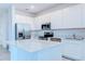Modern kitchen features white cabinets, stainless steel appliances, and a stylish island with white countertops at 3239 Laurent Loop, Davenport, FL 33837