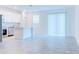 Open living space with tile floor and a view into the kitchen, flooded with natural light from a large window at 3239 Laurent Loop, Davenport, FL 33837
