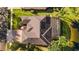 A high angle shot of a brown roofed house featuring a screened in porch next to a serene pond at 3418 Turningwind Ln, Winter Garden, FL 34787