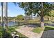 Beautiful backyard featuring brick patio with calming lake views, mature landscaping, and black metal fence at 3418 Turningwind Ln, Winter Garden, FL 34787