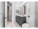 Well-lit bathroom with double vanity, framed mirrors, toilet, and frameless glass shower at 3418 Turningwind Ln, Winter Garden, FL 34787