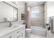 Modern bathroom with gray tiled walls, white vanity, framed mirror and combined shower and tub at 3418 Turningwind Ln, Winter Garden, FL 34787