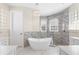 Luxury bathroom featuring a modern freestanding tub, dual vanities, and marble accents at 3418 Turningwind Ln, Winter Garden, FL 34787