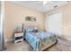 Comfortable bedroom featuring a patterned bedspread, bedside table, and wall art at 3418 Turningwind Ln, Winter Garden, FL 34787