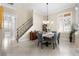 Dining area features a modern chandelier, staircase, and abundant natural light from a window at 3418 Turningwind Ln, Winter Garden, FL 34787