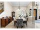 Elegant dining room featuring modern chandelier, staircase, and large window with plantation shutters at 3418 Turningwind Ln, Winter Garden, FL 34787